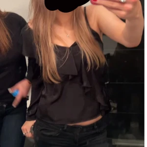 Svart offshoulder blus med volang - Jätte snygg fest topp. Långärmad på ena sidan och en linnes ärm på andra 