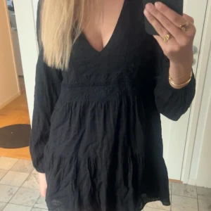 Svart långärmad klänning med v-ringning - Säljer en jättefin kort svart långärmad klänning från Zara. Säljer den eftersom den är för kort, då jag är 180 cm❤️Den är i storlek S🥰
