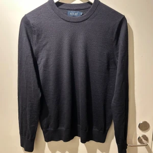 Marinblå merinoull tröja - En marinblå tröja i merinoull från Riley. Tröjan är i väldigt bra skick och perfekt för en stilren outfit. Nypris ligger på runt tusen lappen skulle jag tro. Skicka pm om du har några funderingar!