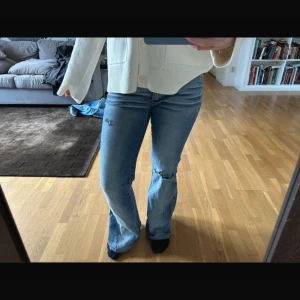 Blå bootcut jeans med slitningar - Säljer ett par blå lågmidjade bootcut jeans i storlek 38 med slitningar på knäna. Säljer dom för de inte passar, ej använda. 💘 