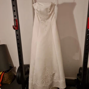 Brudklänning - Säljer denna superfina brudklänning från Romantica stl 12, inköpt på Bröllopsbutiken på St eriksgatan. Den är använd enbart 1 gång men är dock inte kemtvättad💕Klänningen har vackra broderade detaljer och pärlor!