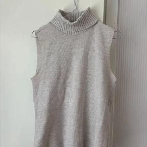 Beige ärmlös polotopp från Zara - Säljer en beige ärmlös polotopp från Zara med ribbad krage. Passar mig som bär S/M. Tveka inte på att höra av dig vid frågor eller prisförslag!