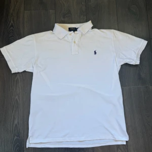 Ralph Lauren piké vit - En riktigt fräsch och snygg Ralph Lauren piké som är i nyskick!  Märke • Ralph Lauren  Skick • 10/10 Storlek • L Modell • Piké med blå loga  Färg • Vit Frakt • skickas samma dag eller dagen efter köp Skriv gärna för mer information!