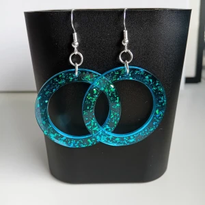 Egentillverkade örhängen  - Egentillverkade örhängen gjorda i resin/epoxy. Öronkroken är nickelsäker och aldrig använda. Längd ca 5.2cm långa