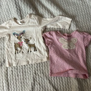långärmad tröja med rådjur och rosa kortärmad topp med fjäril - Två gulliga tröjor för barn: en beige långärmad med rådjurstryck och blommor storlek 68. samt en rosa kortärmad topp med vit spetsfjäril och små prickar storlek 62