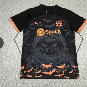 FC Barcelona Halloween fotbollströja - Unik svart och orange FC Barcelona fotbollströja från Nike med Halloween-tema. Framsidan har ett stort pumpa-motiv, fladdermöss och klubbmärke i orange. Spotify-logga på bröstet. Kortärmad modell med orange detaljer vid ärmslut.