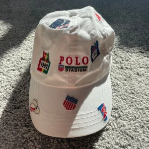 Vit keps från Polo Ralph Lauren  - En helt oanvänd Polo Ralph Lauren keps men ett häftigt mönster. Gött med keps inför den soliga sommaren. Kepsen köptes för 800 kronor. Gör det enda rätta och slå till på detta kap!