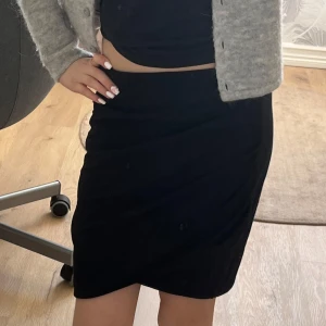 Svart tight kjol  - Svart tight kjol från H&M med enkel och stilren design. Kjolen är kort och har en elastisk midja som gör den bekväm att bära. Perfekt att matcha med crop tops eller stickade tröjor. Kosta 150 kr när jag köpte den och den är nästan aldrig använd! ☺️