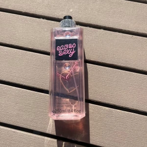 Parfym 'Eau So Sexy' från Victoria's Secret - Säljer en rosa parfymflaska 'Eau So Sexy' från Victoria's Secret. Flaskan rymmer 250 ml och har en snygg, fyrkantig design med svart och rosa etikett samt ett hjärtmotiv på baksidan. Perfekt för dig som gillar söta och fräscha dofter.