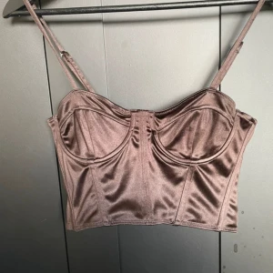 Brun satin korsett topp - Aldrig använd, prislappen är dock avdragen:/ Säljer då den aldrig kom till användning