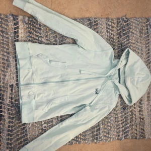 Helly Hansen kofta - Säljes då den ej kommer till användning. Ärvd från mamma så osäker hur använd men är i bra skick endast dragkedjan (se bild)! Osäker på vilken storlek då ingen lapp finns på insidan (mått kan fås privat)