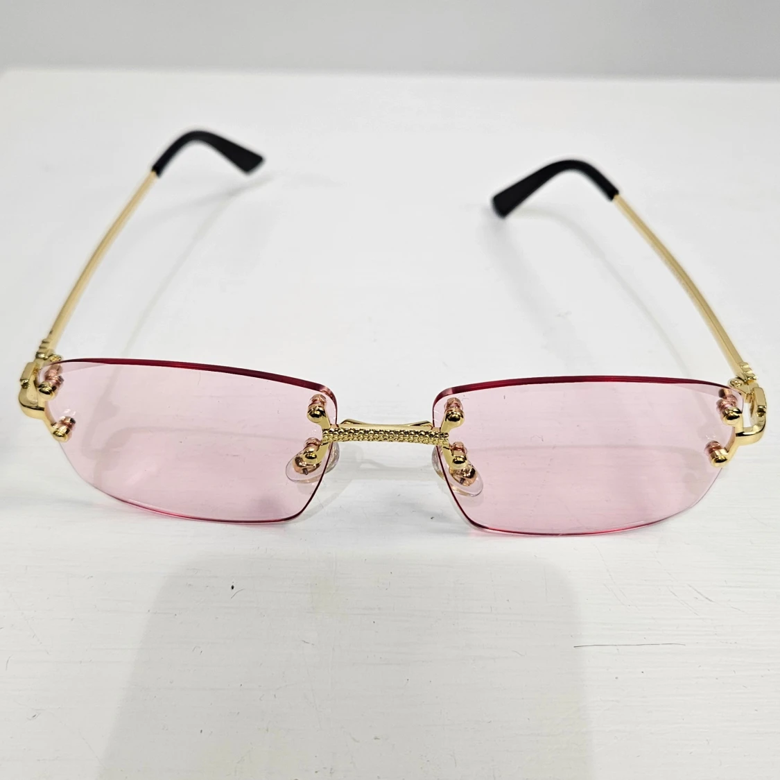 Rosa rektangulära solglasögon med gulddetaljer