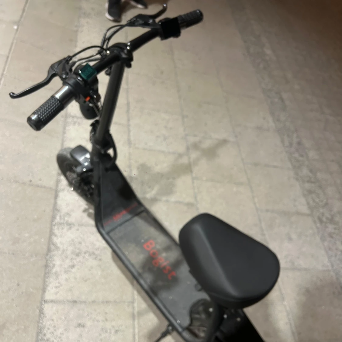 Svart elscooter med sadel