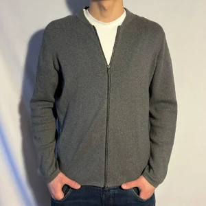Grå kofta från Massimo Dutti - Säljer en stilren grå kofta från Massimo Dutti med dragkedja framtill. Perfekt för lager-på-lager och passar till många olika outfits. Koftan har en enkel design.