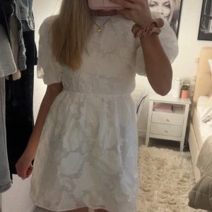 Vit kortklänning med puffärmar och öppen rygg - Supersöt vit kortklänning med puffärmar och öppen rygg med knyt. Perfekt nu till skolavslutning, student eller konfirmation 💓helt ny med prislapp kvar, säljer för hittade en annan klänning jag ville ha 💓💓nypris 600😇😇