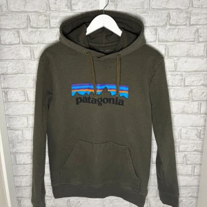 Patagonia Hoodie - Olivgrön Patagonia Uprisal hoodie i storlek M (regular fit) med det klassiska patagonia trycket framtill. Mycket bra skick, sparsamt använd.     Hör av dig vid intresse 🙌