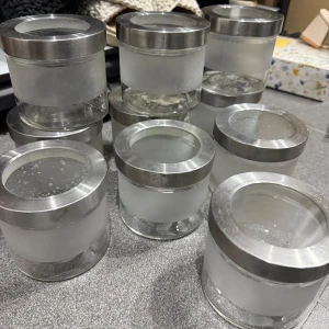 Frostade glasburkar med metallock - Säljer flera stilrena glasburkar med frostat glas och metallock. Perfekta för förvaring av småsaker eller som dekorativa element i hemmet. Burkarna har en modern design med en kombination av glas och metall som ger ett elegant intryck.