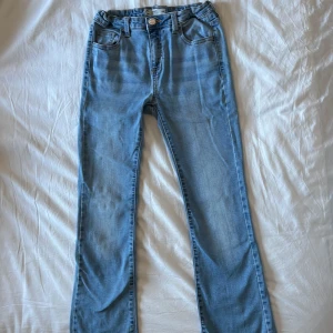 Blå bootcut jeans - Säljer ett par ljusblå bootcut jeans från Cubus barnavdelning. Storlek 158 men passar som 32. Pris kan diskuteras 