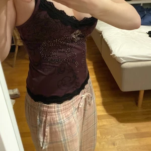 Lila linne med diamanter på - Ett snyggt lila linne som har ett coolt mönster med diamanter och svarta linjer på, alla diamanter är kvar. Linnet är XXS men skulle mer säga XS-S. Har använts en gång.