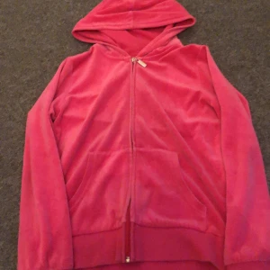 Rosa hoodie med dragkedja - Säljer en mysig rosa hoodie med dragkedja och huva. Perfekt för en avslappnad stil. Den har långa ärmar och en praktisk ficka framtill. Passar bra för kyligare dagar.
