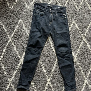 Replay byxor - Snygga mörkblå jeans från Replay med klassisk femficksdesign och kontrastsömmar. Jeansen har en slim passform och är tillverkade i ett slitstarkt denimtyg. Perfekta för en stilren look. Byxorna är mörkblåa (ser svarta ut på bilderna). Byxorna är bara använda ett fåtal gånger. Skriv om ni har frågor eller diskutera pris!!