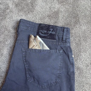 Mörkblå byxor från Jacob Cohen - Snygga mörkblå byxor från Jacob Cohen med klassisk femficksdesign. Byxorna har en normal passform och är tillverkade i ett bekvämt material. Skicket är sprillans nya. Storlek 34 passar rätt så normalt kanske lite mer mot 33.            Pris 1399