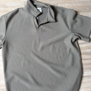 Beige pikétröja från Selected Homme - Säljer en stilren beige pikétröja från Selected Homme. Tröjan har en klassisk krage och korta ärmar, perfekt för en avslappnad men snygg look. Materialet är ribbat vilket ger en extra touch av stil. Passar utmärkt för både vardag och mer uppklädda tillfällen.