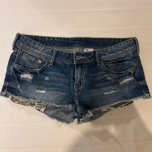 Lågmidjade jeansshorts med leoparddetaljer - Lågmidjade jeansshorts, gammal modell från hm. Fickorna sticker ut vid shorts benet och har leopardmönster. Storleken är 38, sitter mer som S💕 se sista bilderna för midjemått!