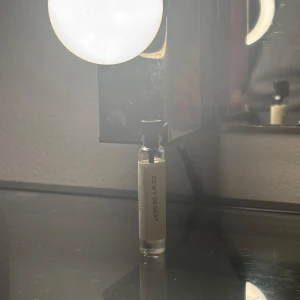 Dewy Desert parfymprov - Ett litet parfymprov med namnet Dewy Desert. Flaskan är genomskinlig med en enkel etikett. Perfekt för att testa doften innan du köper en större flaska.