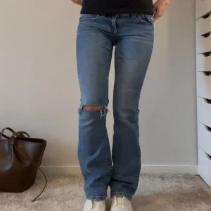 Lågmidjade jeans - Utsvängda lågmidjade jeans, från Gina storlek 32. Knappt använda med hål.