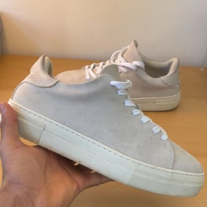 Beige sneakers i mocka, Selected home - Snygga beige sneakers i mocka med vit sula och snörning. Perfekta för en stilren look. De har en rund tå och är tillverkade i ett mjukt material som ger en bekväm passform.
