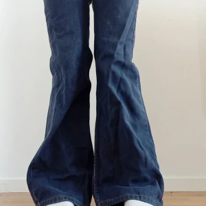Blå bootcut jeans - Snygga mörkblå bootcut leviś jeans med låg midja. Perfekta för en avslappnad stil med en touch av retro. Passar bra till både sneakers och klackar. Lite slitage vid låret då dom är för små men det kan lätt fixas vid säljning