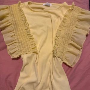 Gul top med utsvängda ärmar & detaljer - Snygg gul top från new yorker. Aldrig använt.