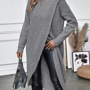 Grå stickad lång tröja - Säljer en stilren grå stickad lång tröja med långa ärmar. Tröjan har en öppen design framtill och är ribbad för extra textur. Använd 1-2 gånger.