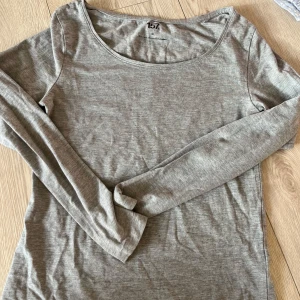 Grå långärmad topp från 157 - Säljer en stilren grå långärmad topp från 157. Tillverkad i en mjuk blandning av bomull, viskos och elastan för en bekväm passform. Perfekt för en avslappnad look.🩷🩷
