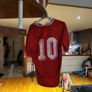 Klassisk 90s Liverpool fotbollströja  - Säljer en asfrän retro Liverpooltröja med nummer 10 på ryggen. Den har en vit krage och är i storlek S, men passar även M. Tröjan är i nytt skick. Hör av dig om du har några synpunkter på priset!