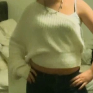 Vit ribbad offshoulder tröja - Säljer en snygg vit ribbad tröja med offshoulder-design. Tröjan är croppad och har en avslappnad passform, perfekt för en trendig look. Passar bra till både jeans och kjol.