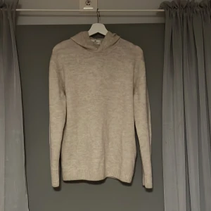 Beige stickad hoodie från H&M - Säljer en mysig beige stickad hoodie från H&M. Perfekt för kyliga dagar med sin mjuka och bekväma passform. Tröjan har långa ärmar och en praktisk huva. Passar utmärkt för både vardag och avslappnade tillfällen. Aldrig använd då den inte passa min stil!