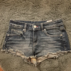Jeansshorts med fransar - Snygga jeansshorts i mörk tvätt med fransiga kanter❤️De sitter under naveln så jag skulle säga low waist❤️Bara använda 1 gång❤️