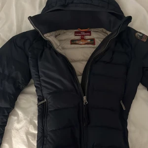 Mörkblå dunjacka från Parajumpers - Säljer en mörkblå jacka från para jumpers i st xs skulle jag tro. Säljer på grund av att den är för liten. Jätte fin passform går in vid midjan lite och funkar som en vår jacka💓 pris kan diskuteras!!