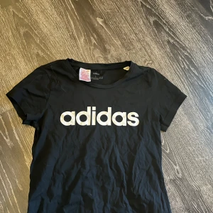 Svart t-shirt från Adidas - Säljer en svart t-shirt från Adidas med text på bröstet. Passar som storlek xs/xxs