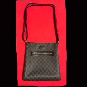 Mönstrad axelväska med dragkedja - Snygg Gucci axelväska med ett diskret mönster och praktisk dragkedja framtill. Väskan har en justerbar axelrem i kontrasterande färger som ger en stilren look. Perfekt för att bära dina nödvändigheter med stil.