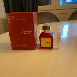 Baccarat Rouge 540 Extrait de Parfum 5ML - Exklusiv parfym från Maison Francis Kurkdjian, Baccarat Rouge 540 Extrait de Parfum. Flaskan är i en elegant röd färg med en gyllene kork och etikett. Förpackningen är också röd med guldtext. En lyxig doft som utstrålar elegans och sofistikation.