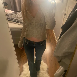 Blå jeans med bootcut - Snygga blå jeans med bootcut-stil och låg midja. Perfekta för en avslappnad look. Klassisk design med knappar och dragkedja framtill.Ganska nya och inte jätte använda 