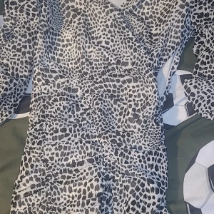 Leopardmönstrad klänning - Snygg leopardmönstrad klänning med v-ringning från Gina tricot. Klänningen har en åtsittande passform och är perfekt för en trendig look.