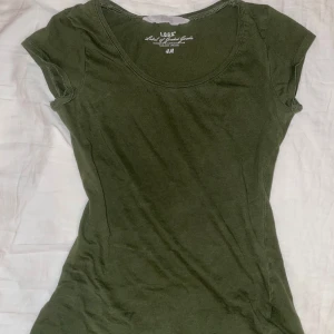 en grön tight passande top - en grön tight passande tshirt från hm. använd några gånger men har förlorat kärleken jag en gång hade för henne så ger över henne till ngn annan som kan älska denna top mer än mig 😜🌟💚
