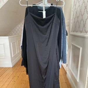 Svart satin långklänning - Lång svart satin klänning med öppen rygg som endast är använd en gång så är i fint skick. Axel banden var för långa för mig när jag skulle ha den så att de är någon millimeter nedkortade men inget som påverkar så mycket💞💞💞