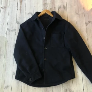 Mörkblå overshirt  - Snygg mörkblå overshirt i ull från uniqlo med knappar framtill och en bröstficka. Den är i storlek xs men sitter som small skulle kunna passa en liten medium också. Bara och skriva om du vill ha mer bilder eller har andra frågor!