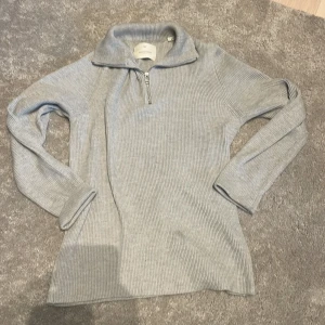 Grå ribbad tröja från Jack & Jones - Säljer en stilren grå ribbad tröja från Jack & Jones. Tröjan har en dragkedja vid halsen och långa ärmar, perfekt för kyligare dagar. Passar bra till både jeans och chinos.