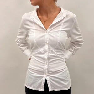 Vit blus med knyt - Snygg vit blus med knytband i midjan och knappar. Storlek 40 från boomerang🙌